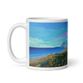 Charger l'image dans la visionneuse de la galerie, White mug featuring a colorful coastal landscape painting with a mountain and blue sea.