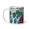 Load image into Gallery viewer, White glossy mug with colorful outdoor café painting, featuring flower pots on white wall and people at red tables